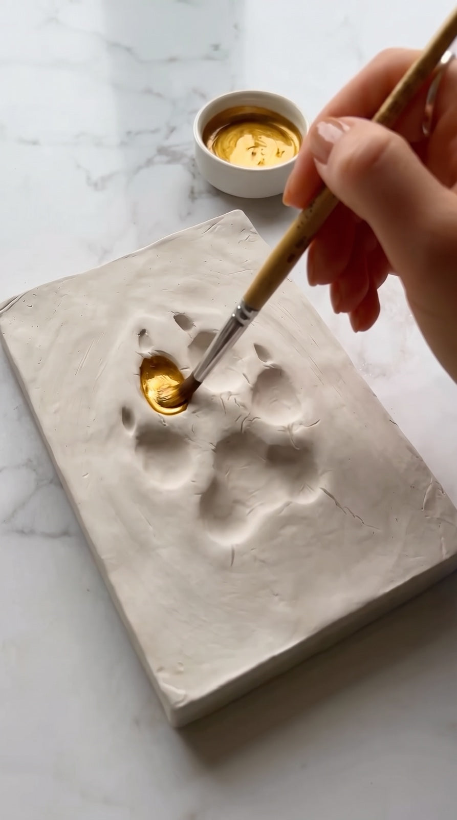 Pintando la huella con pintura dorada
